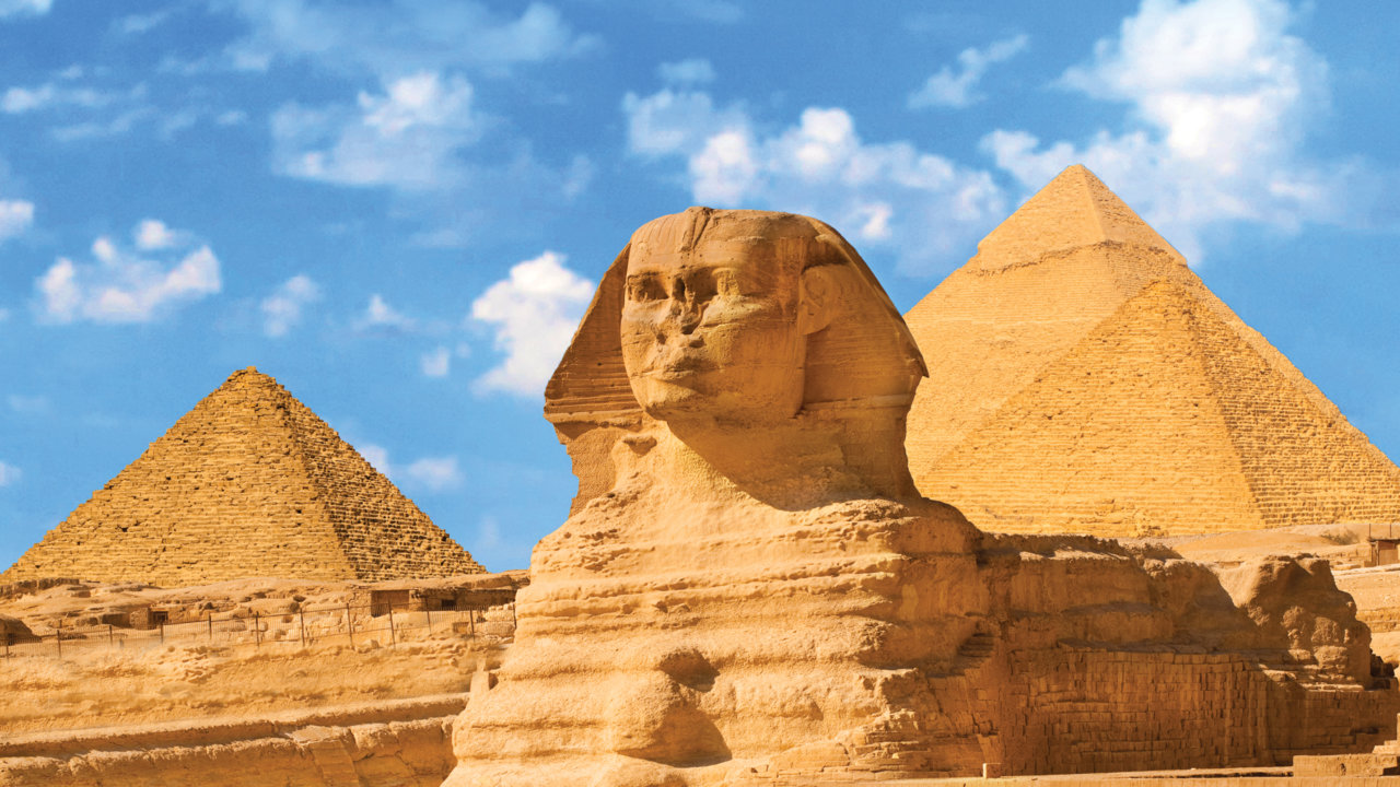 Egyptian Great Sphinx full body portrait with Pyramids in Background, Giza, Egypt
